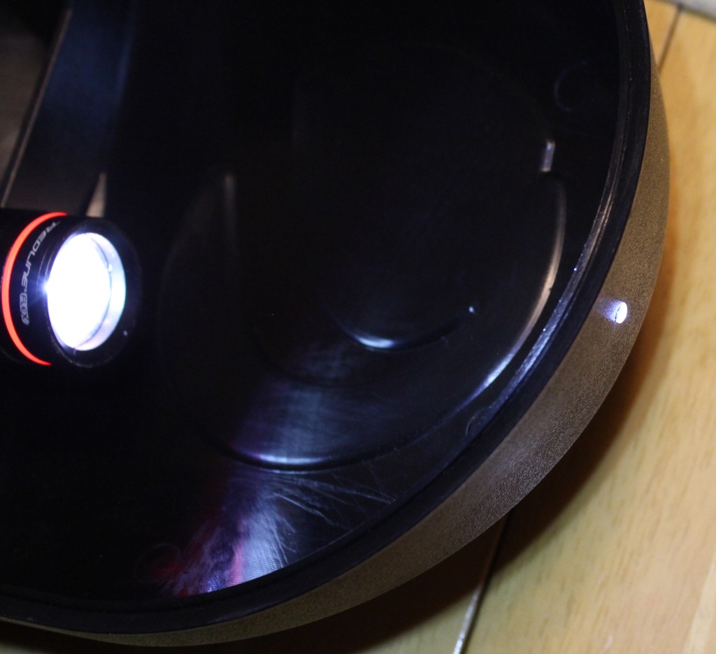 A flashlight is shown pointing into one end of the mounted light pipe, and light is seen emerging from the other end. Illustrates how the light pipe is useful for conduction of light.